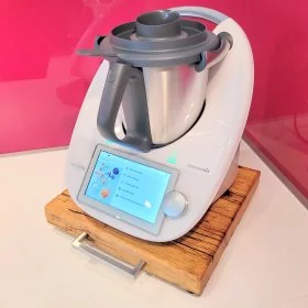 Mobile Preview: Gleitbrett / Rollbrett aus Massivholz für Thermomix, Farbe honey, mit eckigem Edelstahlgriff, in Küche mit Glas-Rückwand